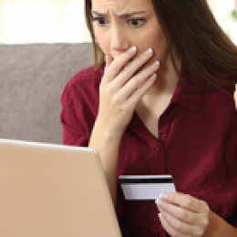 Two women looking concerned at the laptop and holding a credit card