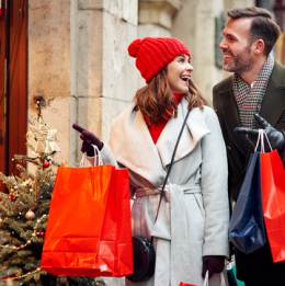 Man and woman smiling at each other and shopping outside during the winter holidays