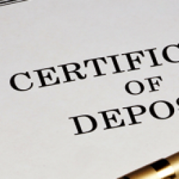 Document that says Certificate of Deposit with a pen lying on top of it