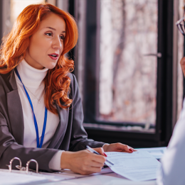 Businesswoman reviewing financial paperwork with man