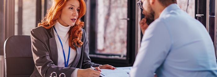 Businesswoman reviewing financial paperwork with man