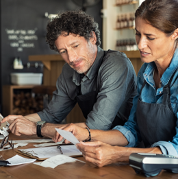 Business owners sitting at table with tables and financial papers