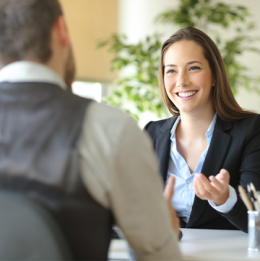 Woman dressed in business casual clothing gesturing and smiling at man