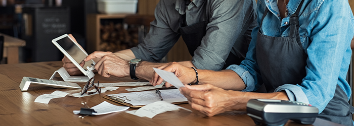 Business owners sitting at table with tables and financial papers